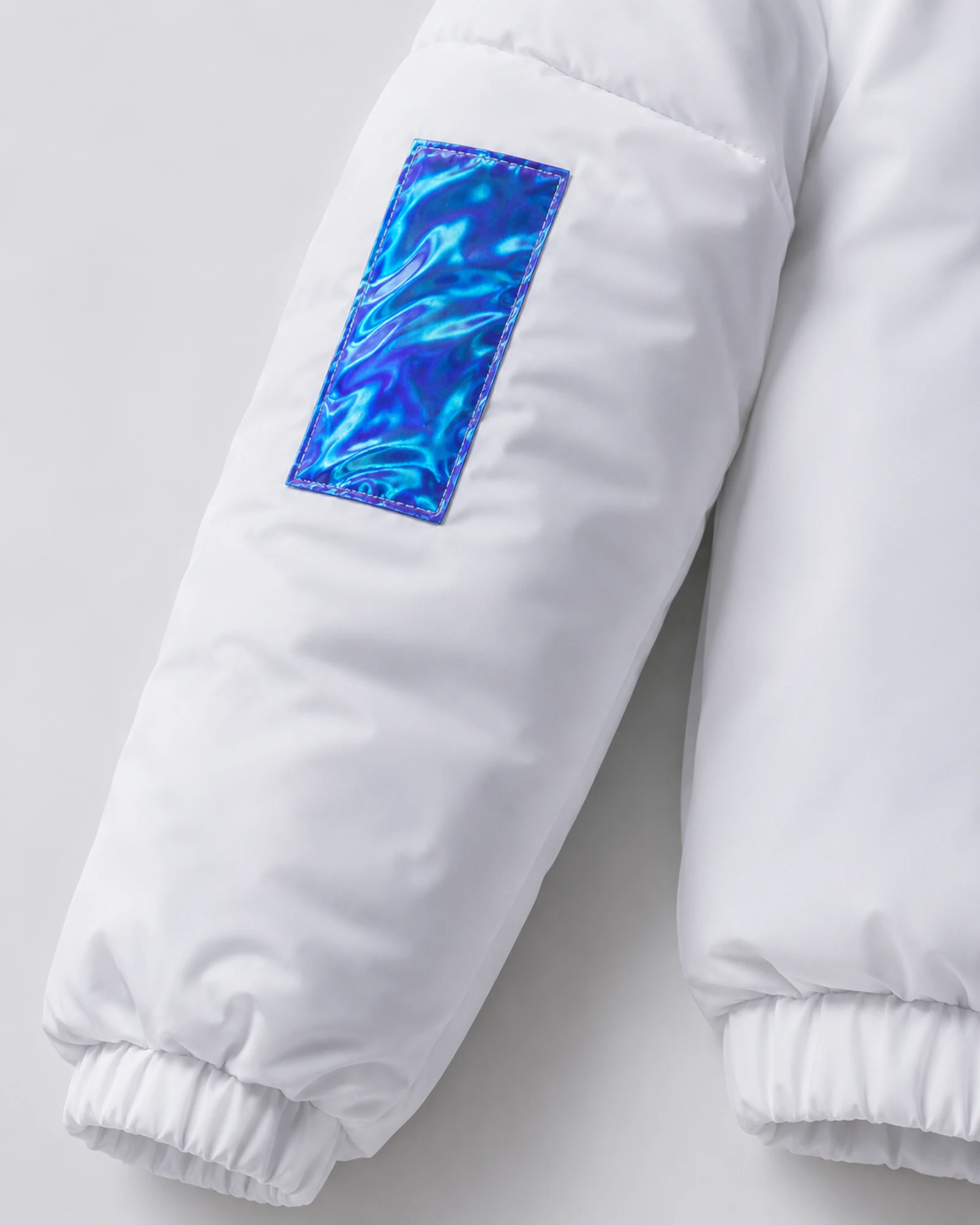 Detail of the white sleeve with an iridescent blue patch